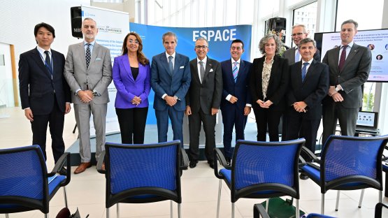 原子能機構總干事拉斐爾·馬里亞諾·格羅西在會外活動中與發言者合照。 （照片來源：D. Calma/國際原子能機構）